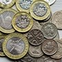 Close up of British coins laid out on a white surface